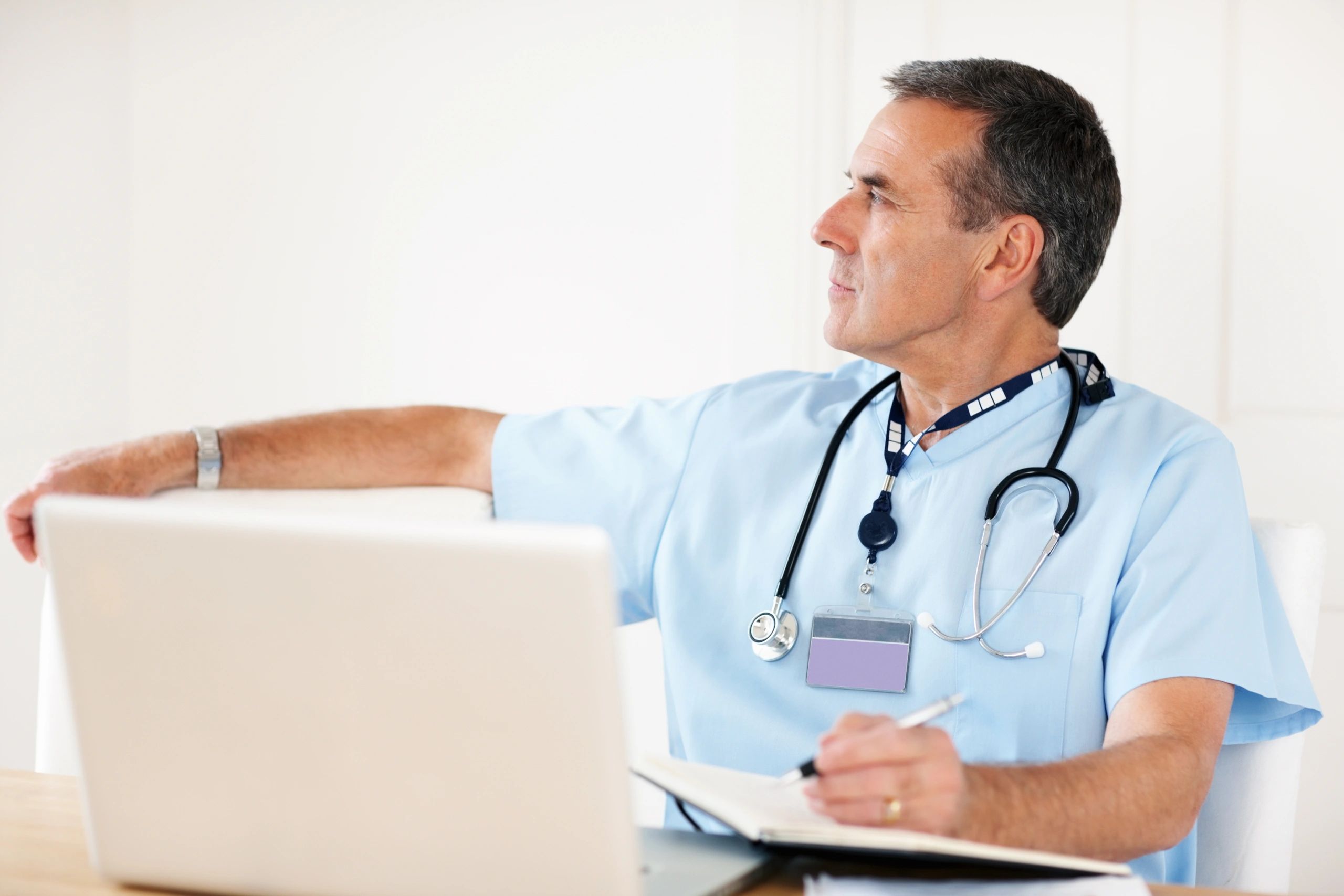 Senior doctor working at a desk with a laptop